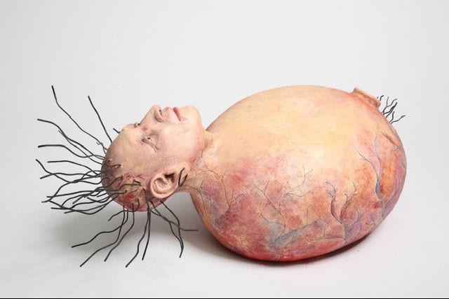 In and Out, a ceramic sculpture by Ireri Krueger of a face emerging from a veined, womb-like form